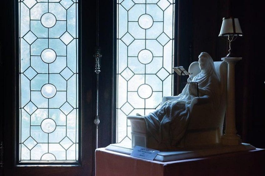 A statue of a seated figure, a stained glass window, and a lamp. 5