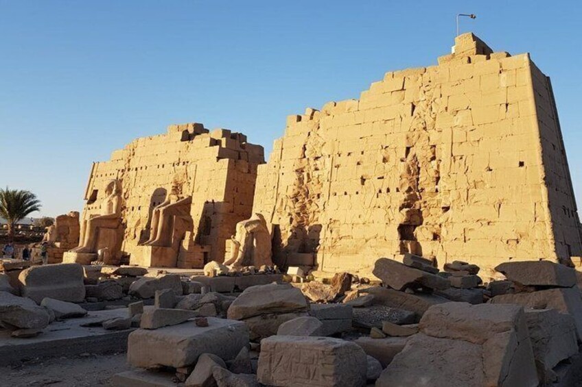 Ancient Egyptian ruins with large stone blocks and statues. 2