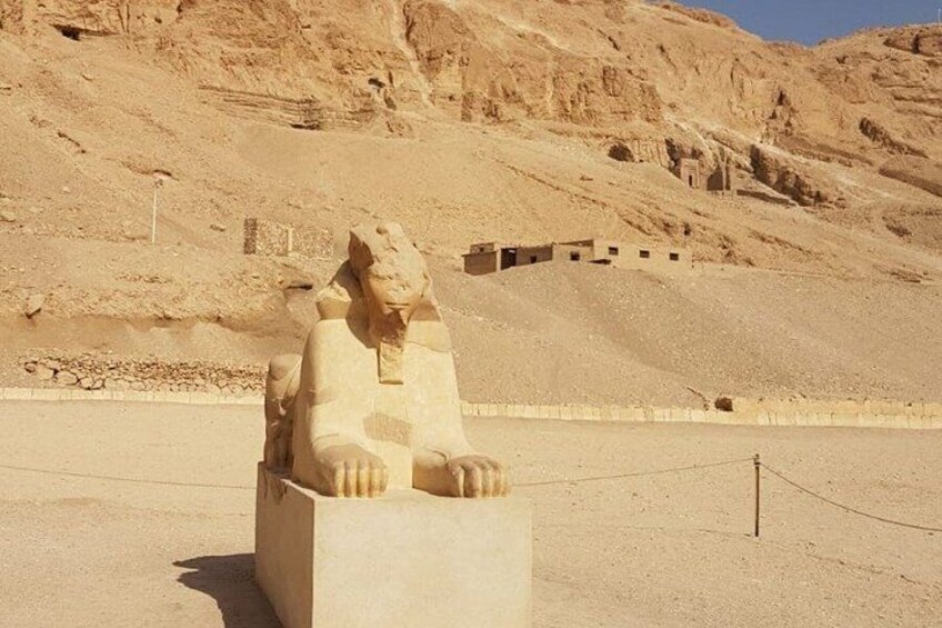 A large stone sphinx statue in a desert setting with a clear sky. 3