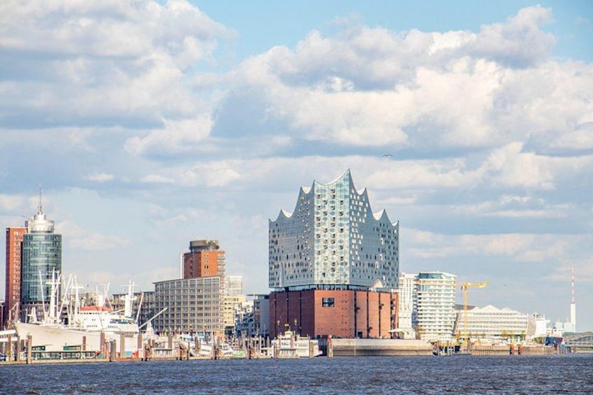 Un paisaje urbano frente al mar con arquitectura moderna, incluyendo un edificio distintivo con una parte superior que recuerda a una corona. 1