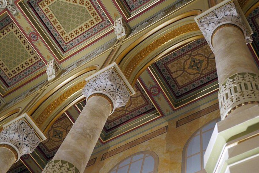Ornate ceiling designs, columns, and arched windows. 3