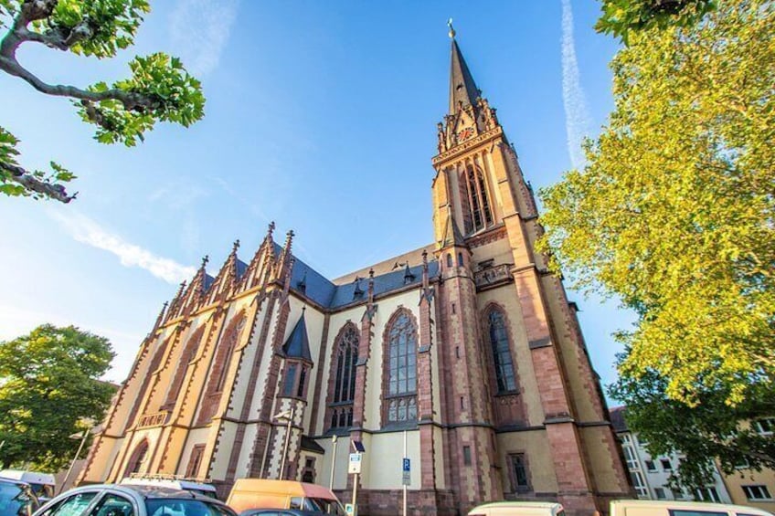 A large church with a tall spire and multiple arched windows. 5