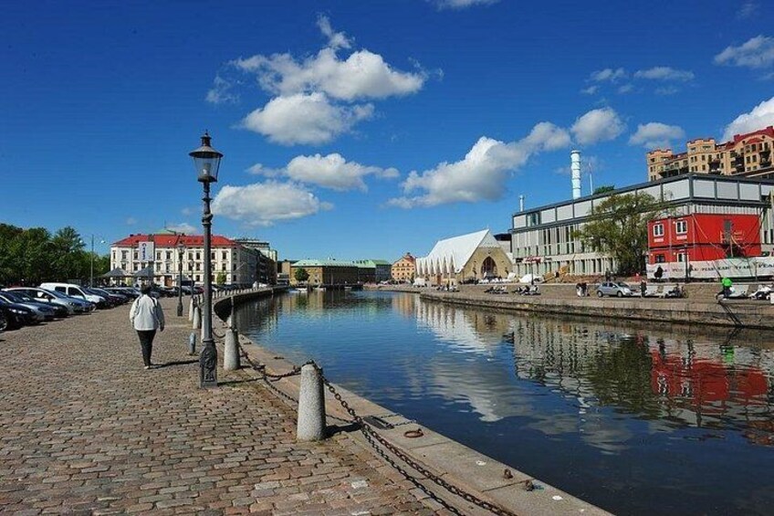 A river with buildings on the right, a pedestrian path on the left, and a clear sky. 2