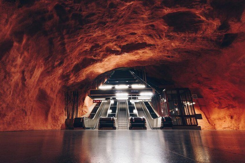 A subway station with escalators and a train platform. 3