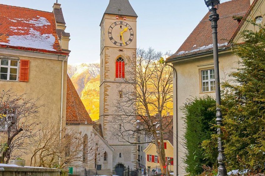A clock tower, a church, and buildings with red shutters. 2