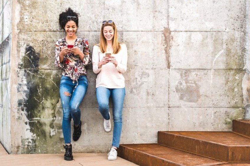 Two people sitting on steps against a concrete wall. 3