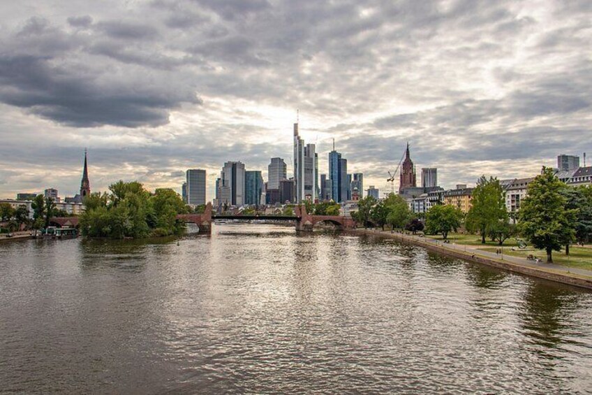 A river with a city skyline in the background, including a prominent church spire and modern buildings. 3