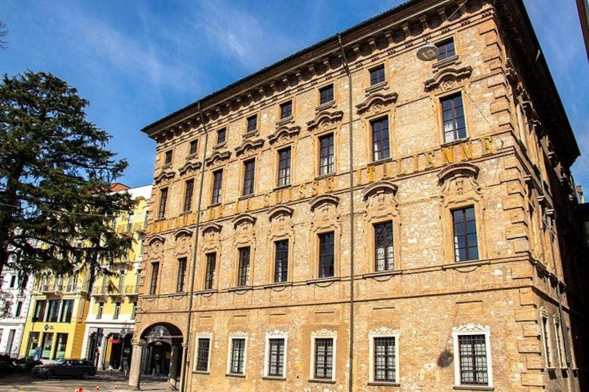 Un edificio storico con architettura decorata, ampie finestre e un ingresso imponente. 1