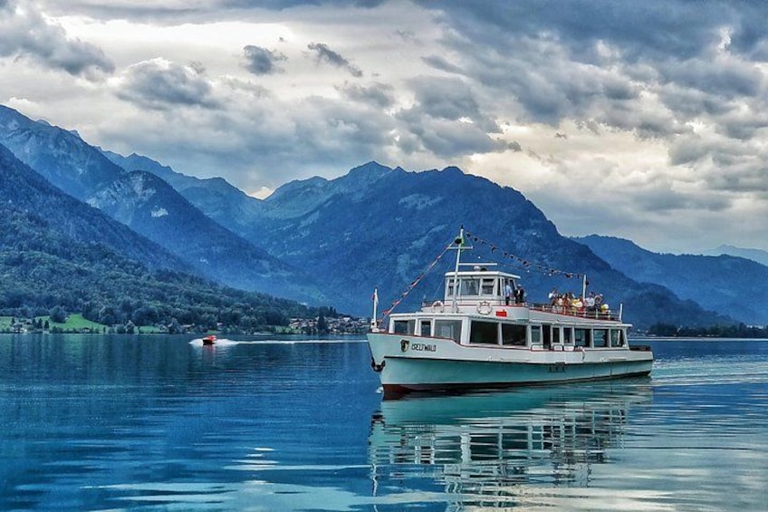 A boat on a calm lake with mountains in the background. 2