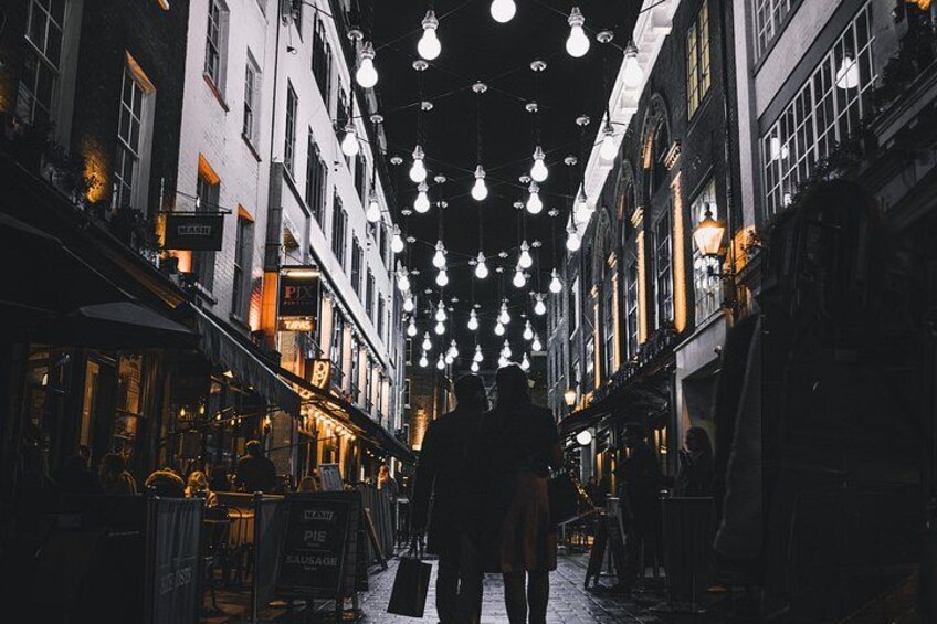 Eine Straße mit hängenden Lampen, Gebäuden und Schildern. 4