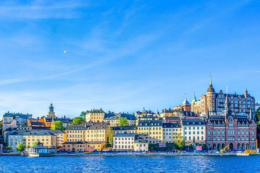 A waterfront cityscape with historic buildings, a river, and a clear sky. 4