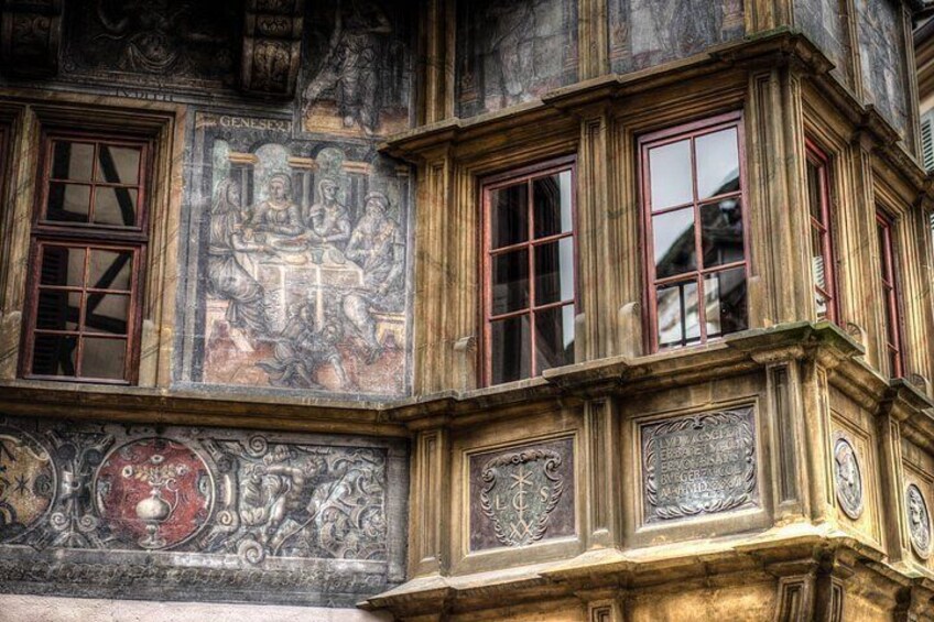 A building facade with intricate stone carvings and a detailed mural. 4