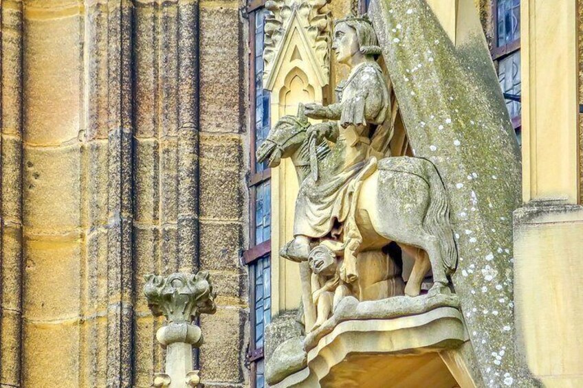 A stone sculpture of a figure on horseback, part of a larger architectural structure. 3