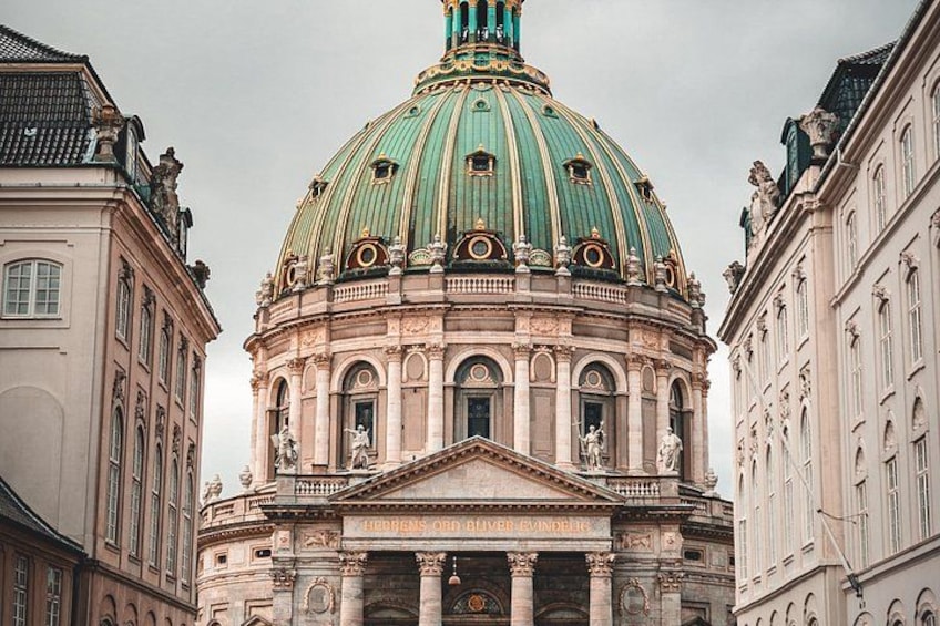 A historic building with a prominent dome, classical columns, and detailed architectural carvings. 4
