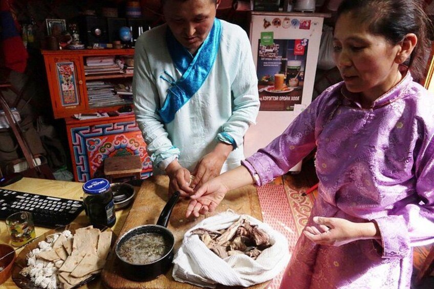Two people preparing food, with ingredients and kitchen tools on the table. 1