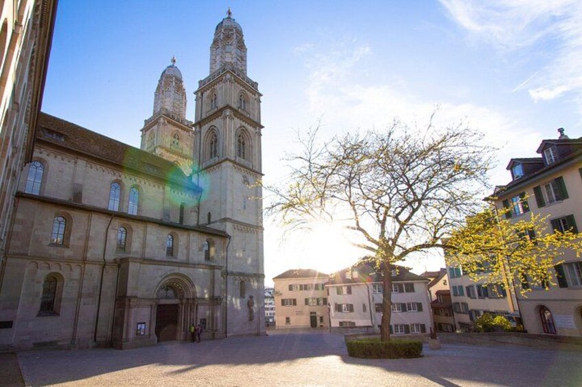 A historic church with twin towers, a courtyard, and surrounding buildings. 4