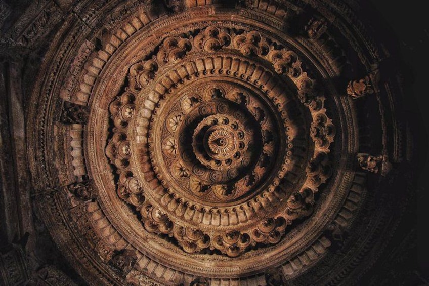 Un escalier en colimaçon détaillé, orné de sculptures complexes et doté d’un motif circulaire central. 3
