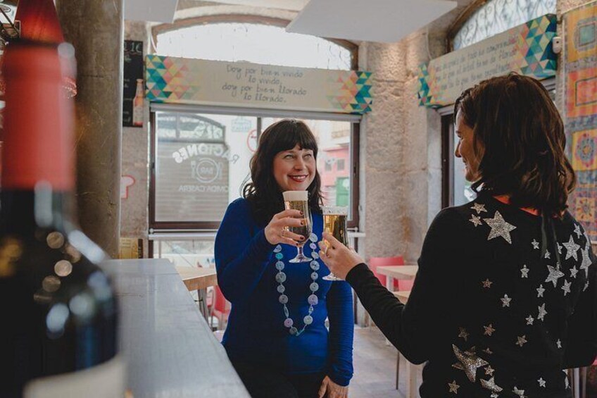 Two people holding glasses, a bottle, and a menu in a restaurant. 4