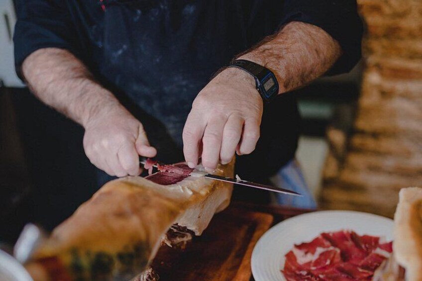 A person slicing meat on a cutting board. 2
