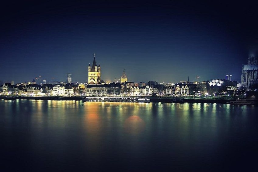 A nighttime cityscape with a prominent tower reflecting on the water. 5