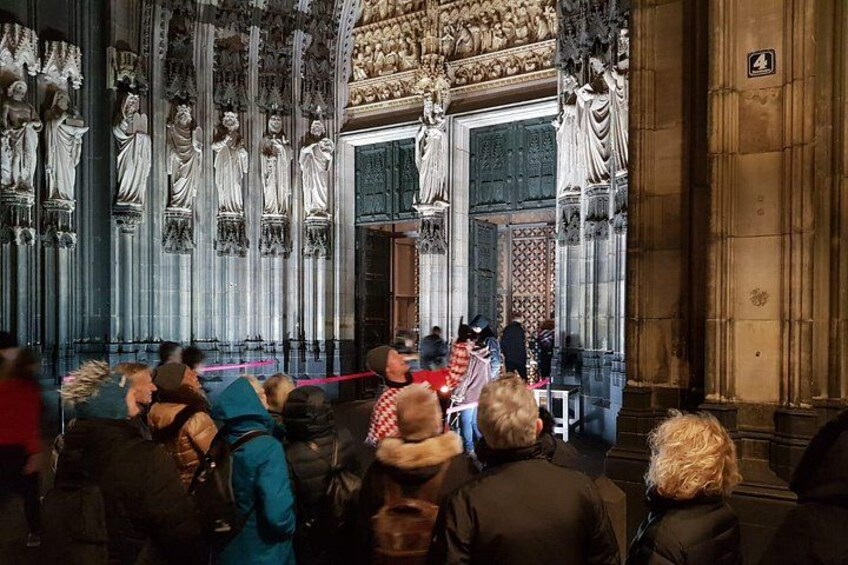 A cathedral interior with statues, a choir, and attendees. 1