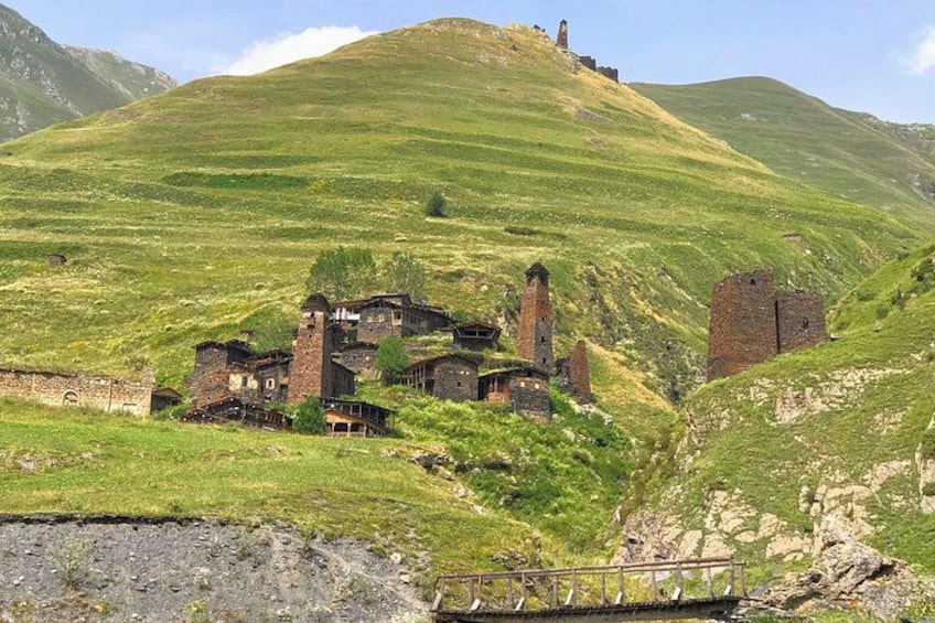 A rural landscape with a hill, a ruined building complex, and a watchtower. 2