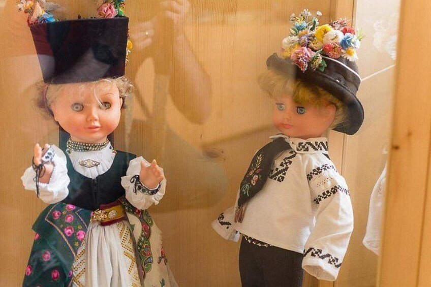 Twee poppen in traditionele kledij met bloemen in hun haar. 3