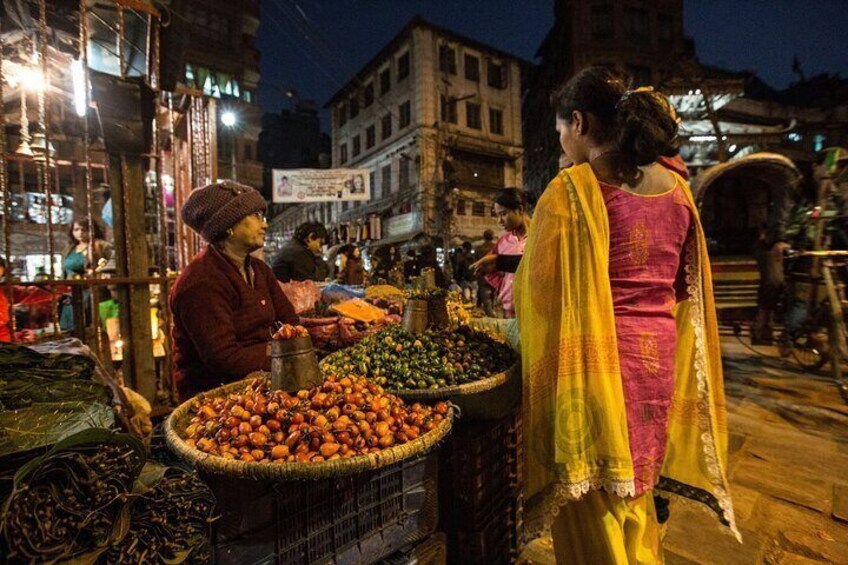 Un mercado nocturno con vendedores ofreciendo frutas y verduras. 2