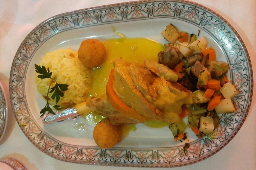 A plate of food with rice, a piece of meat, and vegetables. 4