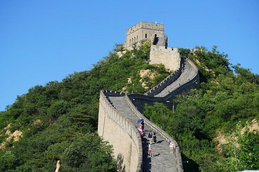 The Great Wall of China winding through a mountainous landscape with lush greenery. 2