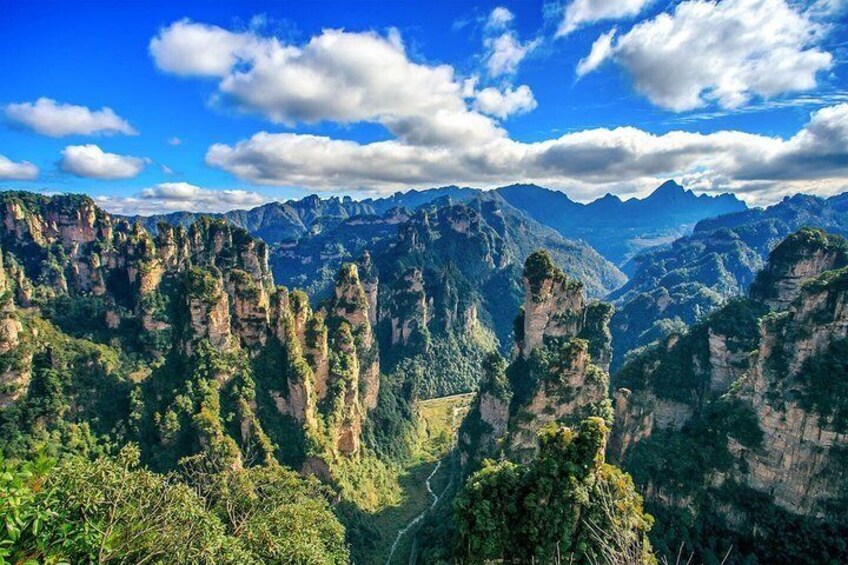 Un paysage montagneux caractérisé par de hautes formations rocheuses étroites et une végétation verte et luxuriante. 2