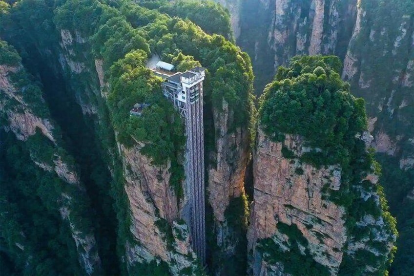 Une haute tour dotée d’une plateforme d’observation, située au sommet d’une falaise abrupte et entourée d’une forêt dense. 5