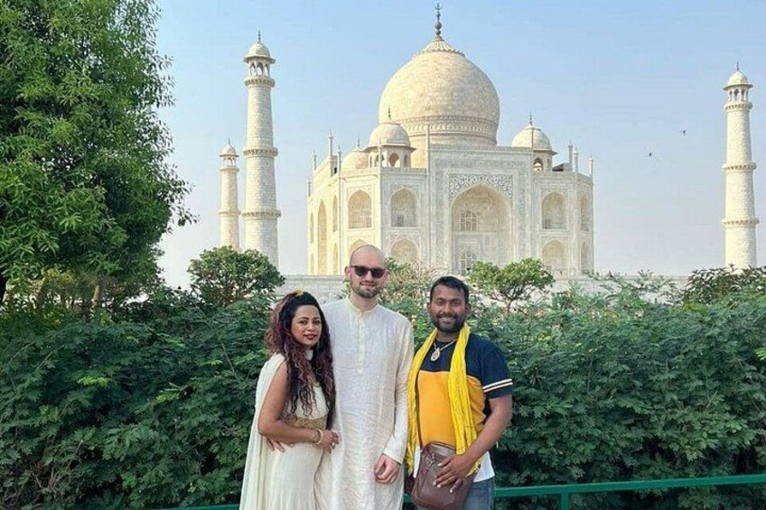 Drie mensen staan voor de Taj Mahal. 2