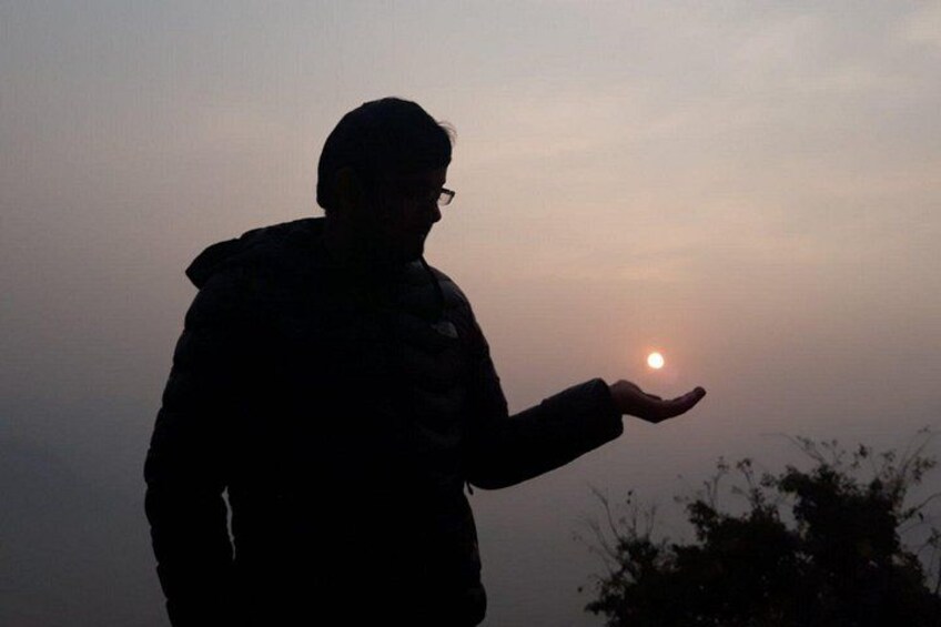 A person silhouetted against a sunset with the sun visible in the sky. 1