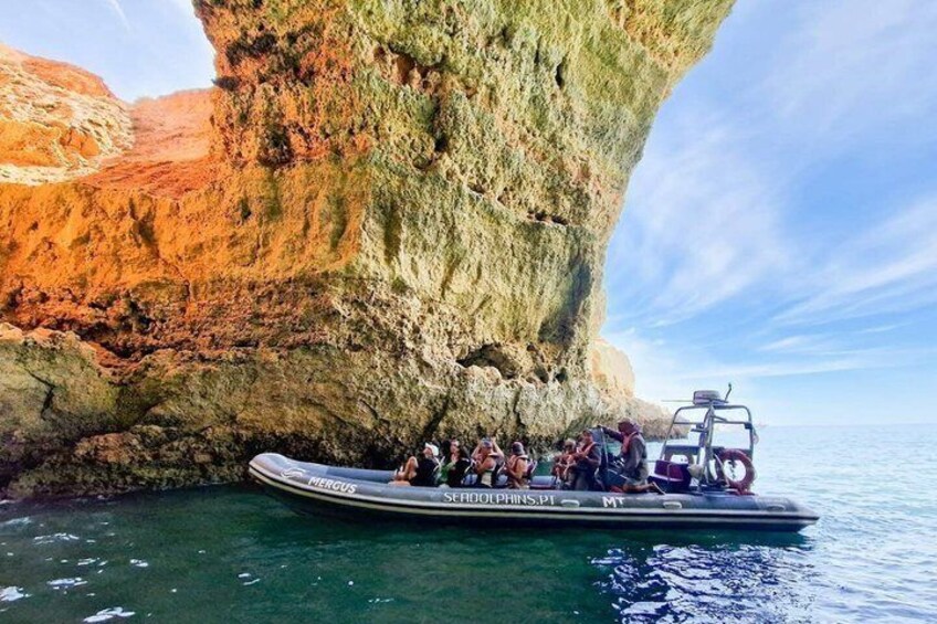 A boat with passengers near a large rock formation. 4