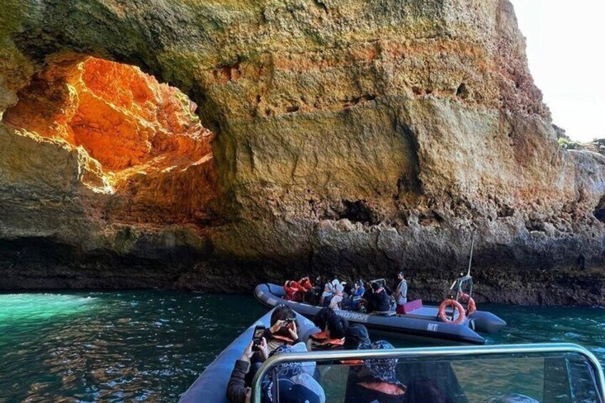 A boat with people on a rocky coastline. 2