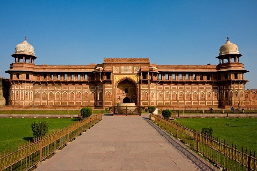 A large, historic building with a central archway, two domed towers, and a symmetrical facade. 2