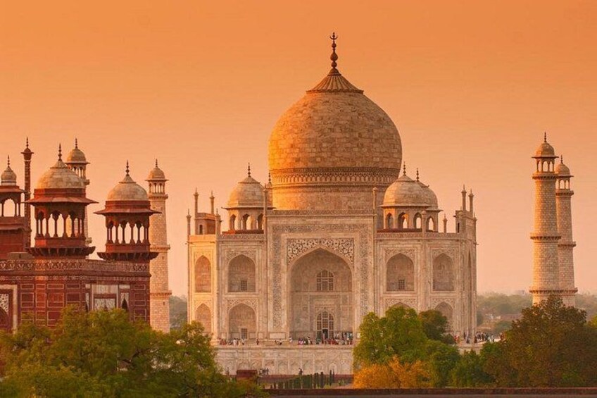 The Taj Mahal with its four minarets and large central dome, surrounded by trees. 1
