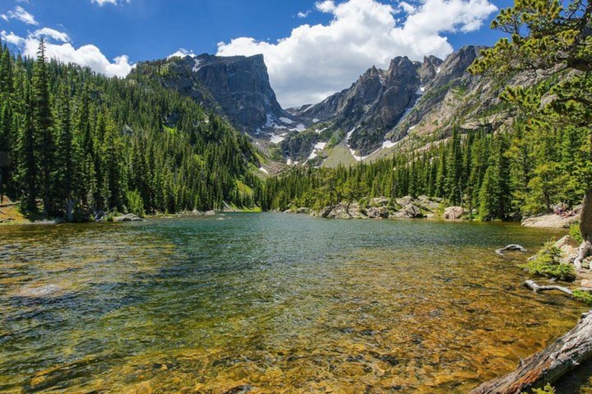 Un lago alpino limpido circondato da fitte foreste e montagne scoscese. 2
