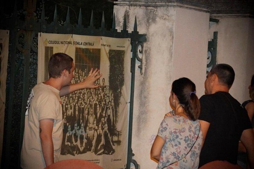 A group of people standing in front of a poster with a large group of people on it. 3