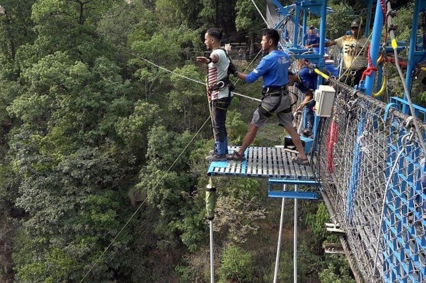 Een zipline-activiteit met deelnemers op een hangend platform, te midden van dicht bos. 4