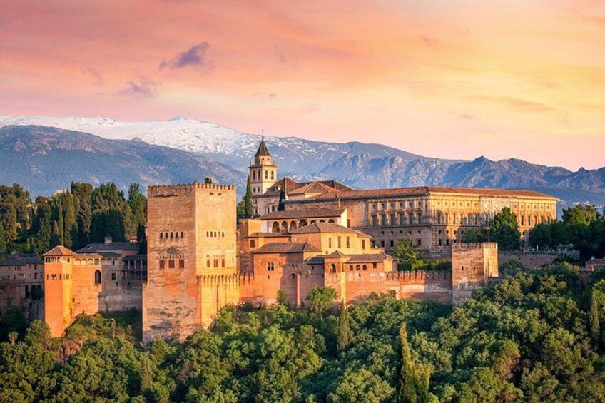 Un château historique, doté de tours, entouré d’une végétation luxuriante et avec des montagnes en toile de fond. 1