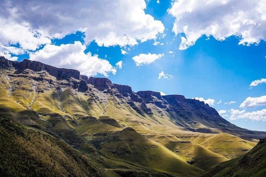 A mountainous landscape with rolling hills and a clear sky. 2