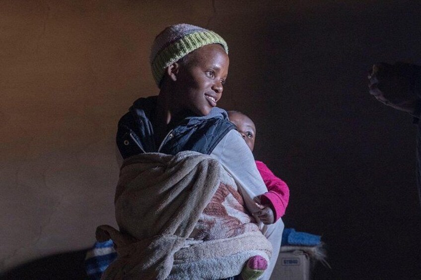 A person holding a child in a dimly lit room. 2