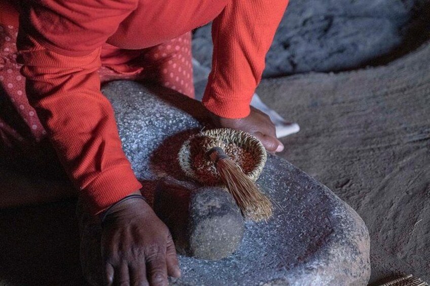 A person in red clothing interacting with a hedgehog on a stone surface. 5