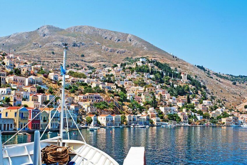 A coastal town with colorful houses, a boat docked in the foreground, and a mountain in the background. 1