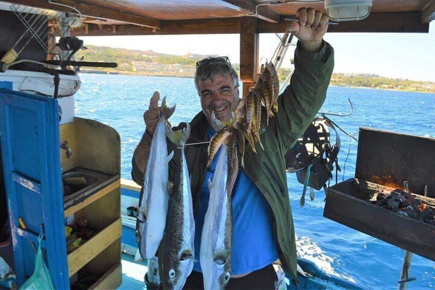 A person holding fish on a boat with a grill and fishing equipment in the background. 4