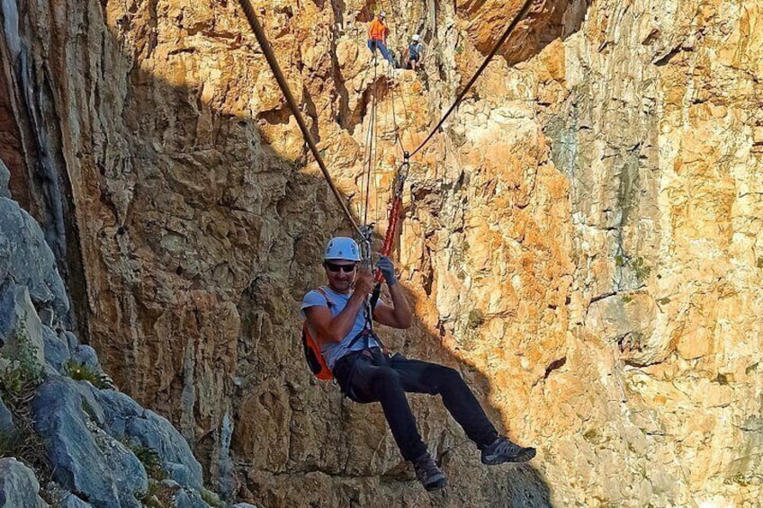 A person rappelling down a rocky cliff. 1