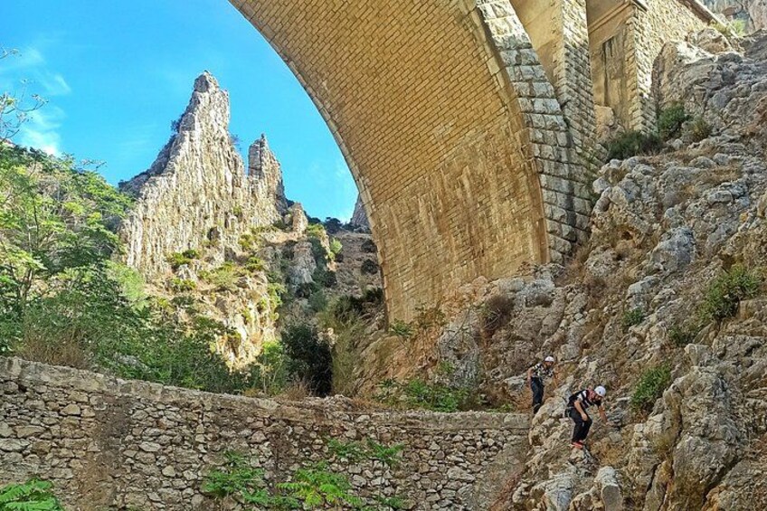 A stone bridge, rocky terrain, and a mountain peak. 2