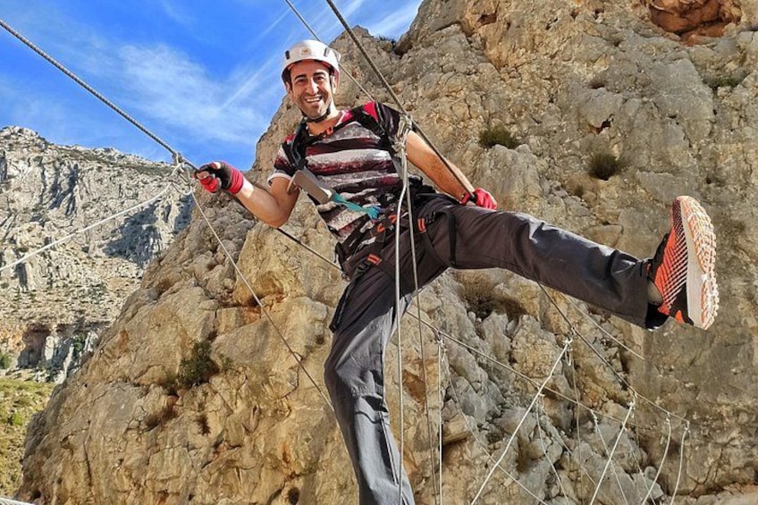 A person rappelling down a rocky cliff with ropes, wearing a helmet and harness. 4